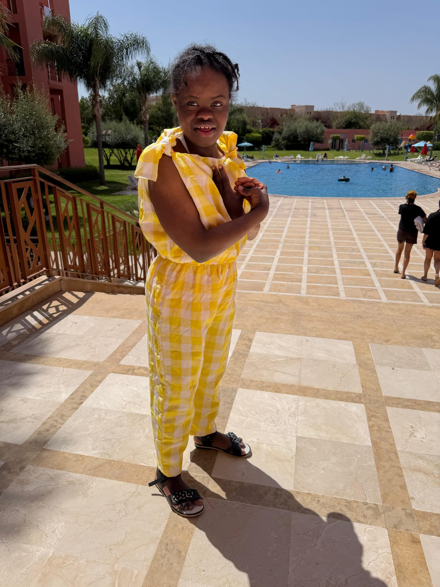 Un enfant souriant au bord de la piscine du riad