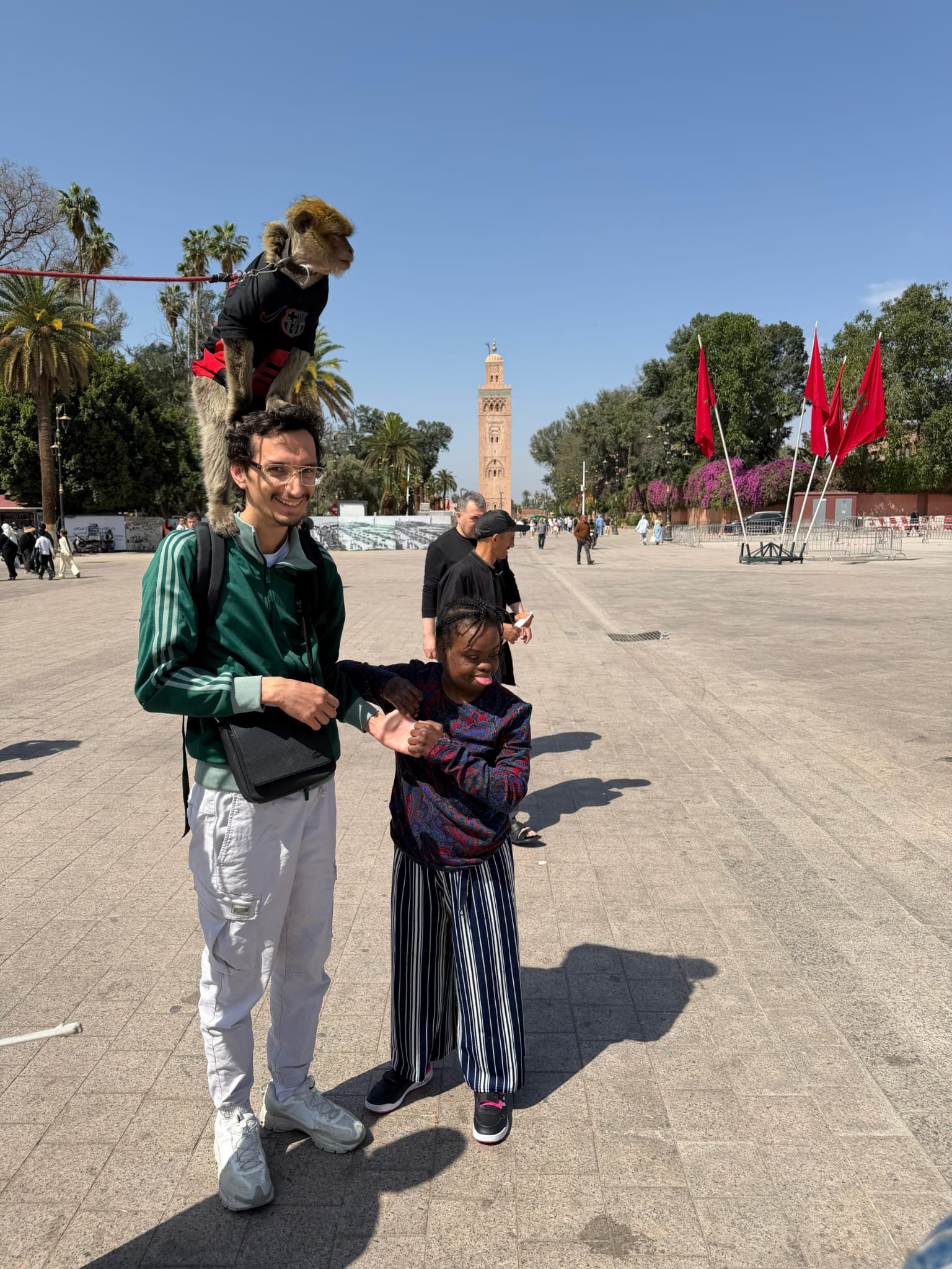 Un éducateur et un enfant marchant ensemble sur une place de Marrakech